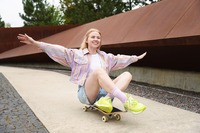 Das Bild zeigt eine Frau auf einem Skateboard. Das Bild zeigt eine Frau, die auf einem Skateboard fährt.