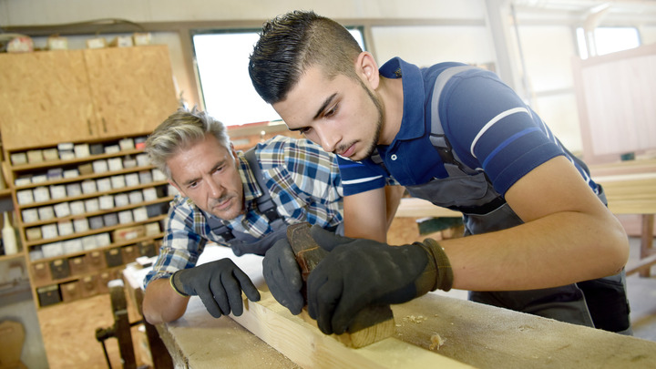 Schreiner beobachtet Lehrling bei der Arbeit