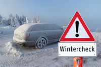 Eingeschneites Auto steht hinter einem Hinweisschild "Wintercheck"