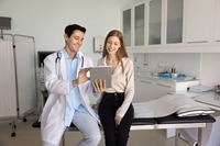 Ein Arzt zeigt einer Patientin Informationen auf einem Tablet. Das Bild zeigt einen Arzt, der einer Patientin Informationen auf einem Tablet vorstellt..